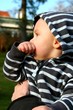 Bébé sucant son pouce dans les bras de sa maman