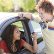 Happy teen shows off car.