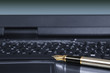 Fragment of laptop with a pen