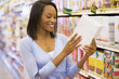 Woman checking food labelling in supermarket