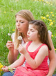 Mother and Daughter Blowing Dandelion Seeds Together