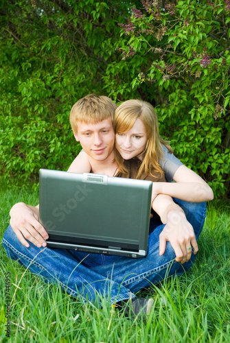 Photo: Pretty young couple with laptop Pretty young couple with laptop
