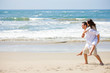 Young man giving piggyback to woman on beach