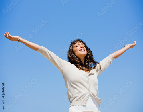 Pretty young woman with arms raised