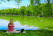Photo: Beautiful young woman with laptop near the lake Beautiful young woman with laptop near the lake
