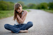 Teenager girl sitting on road