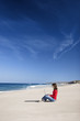 Woman working with a laptop on the beach