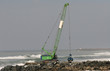 grue en action sur une digue en bord de mer
