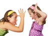 Two young girls fighting and sticking tout heir tongues out 