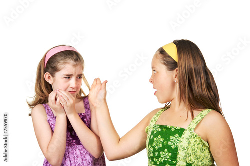 Photo: Two young girls fighting one slapping the other and one scared Two young girls fighting one slapping the other and one scared