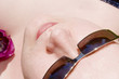 Frau mit  Sonnenbrille und Tulpe beim Sonnenbad