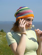 A girl with striped cap talks by phone. A girl with striped cap talks by phone.