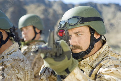 Photo: Soldier aiming rifle, outdoors, close-up Soldier aiming rifle, outdoors, close-up