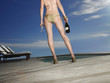 Woman in a Bathing Suit Holding a Bottle of Champagne