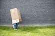 girl running away with a cardboard box over her head