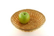 One green apple in the basket