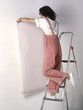 Woman applying wallpaper