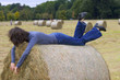 Slim woman on stack of hay