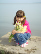 Photo: Little girl with the bouquet on the riverside. Little girl with the bouquet on the riverside.