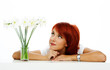 young smiling woman is looking at the flower
