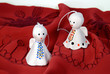 Two angels made of ceramics on a red cloth