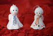 Two angels made of ceramics on a red cloth