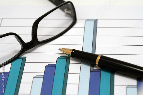 Photo: A pen and glasses on a chart A pen and glasses on a chart