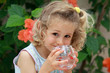 Smailing blond  girl with a glass of water