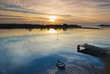 Winter Sunrise over a Glassy River with Boat and Jetty