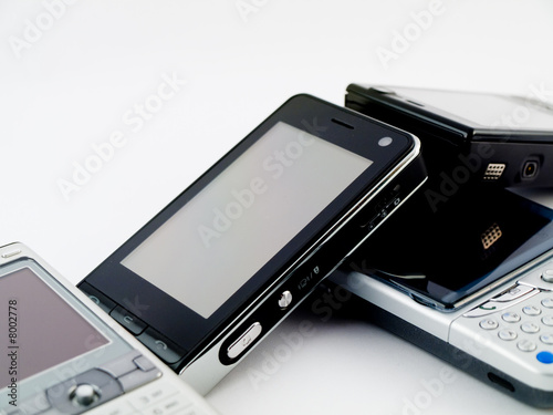 Photo: Several Mobile Phones and a PDA Leaning on Each Other Several Mobile Phones and a PDA Leaning on Each Other