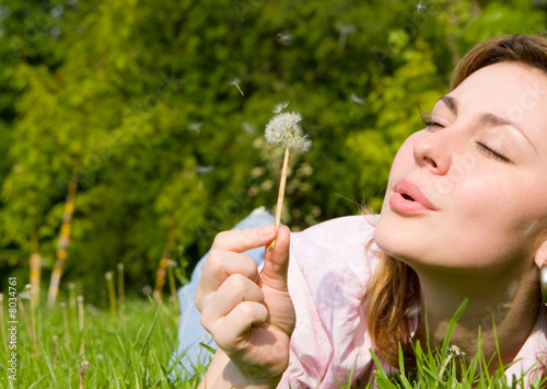 Foto: happy girl blowing on the dandelion happy girl blowing on the dandelion