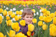 little girl sit on field of tulips