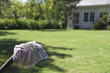 Pair of gardening gloves, garden lawn in background, focus on foreground
