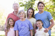 Extended family standing in park smiling
