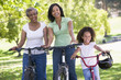 Grandmother with adult daughter and grandchild riding bikes