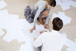 Two business colleagues picking up dropped files and paperwork from the floor