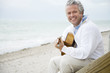 A senior man playing a guitar