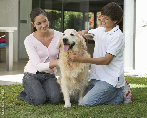 Photo: A brother and sister with their dog in the garden A brother and sister with their dog in the garden
