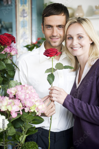 Photo: Couple choosing flowers in a florist's shop, red roses Couple choosing flowers in a florist's shop, red roses