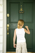 Little girl knocking at the front door of a house
