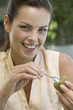 A woman eating kiwi fruit