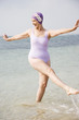 Senior woman in a swimsuit and swimming hat, at the beach