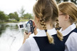 Two schoolgirls using a video camera