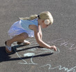 Young girl writing in chalk on the playground