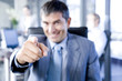 Smiling businessman pointing towards camera