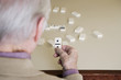 An elderly man playing dominoes