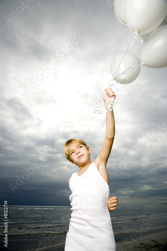 Photo: A young boy with a bunch of balloons A young boy with a bunch of balloons