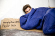 Homeless young man laying in the street