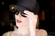 Woman in a baseball cap and sunglasses outdoors