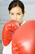A woman wearing boxing gloves on a beach